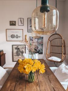 a vase of yellow flowers on a wooden table at Altes Dorfhaus Sechzehneichen in Sechzehneichen