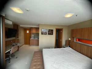 a large bedroom with a bed and a kitchen at Flat no Jade Hotel in Brasilia