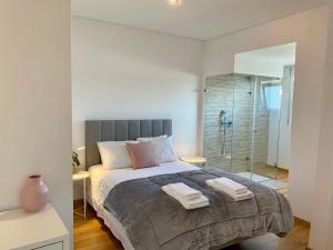 una camera da letto con un grande letto con asciugamani di Lisbon South Bay modern apartment with river view ad Almada
