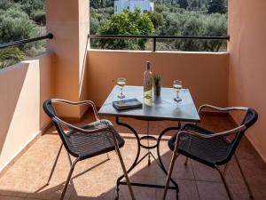 a table with two glasses of wine on a balcony at Villa Helios, private gated pool + big patio in Almirida