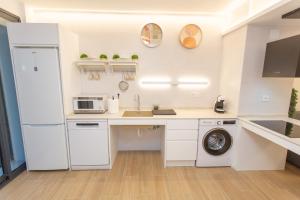 a white kitchen with a sink and a refrigerator at BatFlats - RUZAFA in Valencia