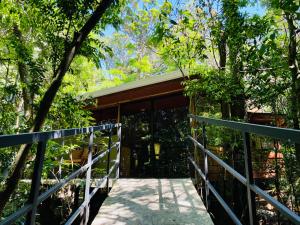 una pasarela que conduce a una casa con puertas de cristal en Cabañas La Montaña Mountain Lodge en Monteverde