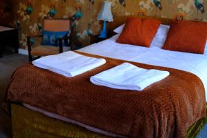 una camera da letto con un letto e due asciugamani di Quirky mid century themed holiday home a Shepton Mallet