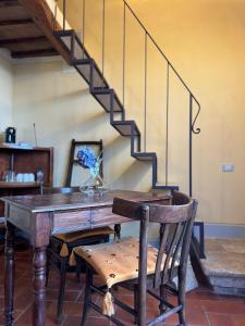 a dining room with a wooden table and stairs at Pienzalettings "Suites" in Pienza