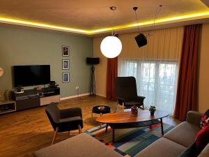 a living room with a couch and chairs and a table at Apartman Donner Centar II in Subotica