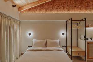 a bedroom with a white bed and a wooden ceiling at 12 PYLES Living History in Ioannina