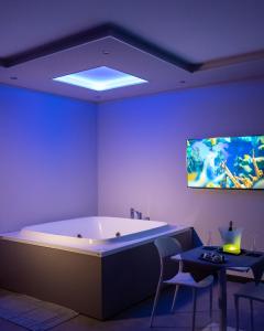 La salle de bains est pourvue d'une baignoire et d'une télévision murale. dans l'établissement Skyline Rooms & Suites, à Grottaminarda