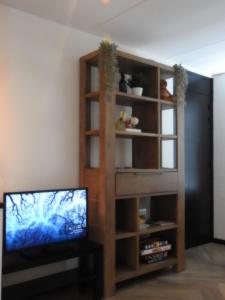 een woonkamer met een tv en een boekenplank bij Luxe Studio Liemers in Lelystad