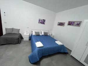 a bedroom with a blue bed with two towels on it at B&B Claustro Mirti in Altamura