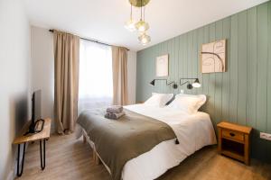 a bedroom with a large bed and a large window at Jeanne - Hypercentre in Orléans