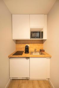 a kitchen with a sink and a microwave at Jeanne - Hypercentre in Orléans