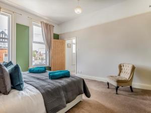 a bedroom with a bed and a chair and a window at 7 Bed in Bridlington 90787 in Bridlington