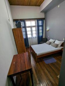 a room with a bed and a table in it at Hôtel Diamant Antsirabe in Antsirabe