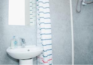 a bathroom with a sink and a shower curtain at Trendy 2BR Apt near Anfield Stadium in Liverpool