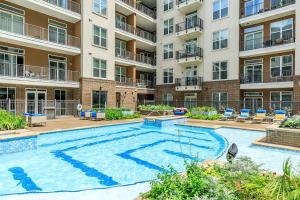 a swimming pool in a apartment complex with a building at Downtown Houston Cozy Queen Suite in Houston