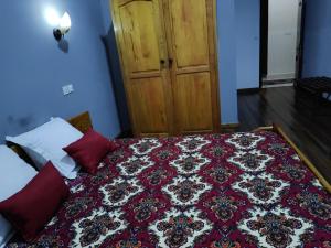 a bedroom with a bed with a rug on it at Hôtel Diamant Antsirabe in Antsirabe