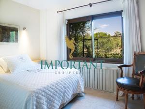 um quarto com uma cama, uma janela e uma cadeira em Villa Mertcan by Important Group Travel em Yalıkavak