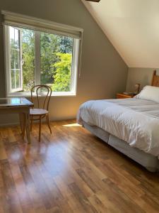 a bedroom with a bed and a table and a window at Casa Viña in Valdivia