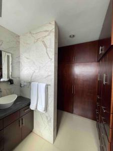 La salle de bains est pourvue d'un lavabo et d'un mur en marbre. dans l'établissement Casa Familiar Diamante, à Heroica Alvarado
