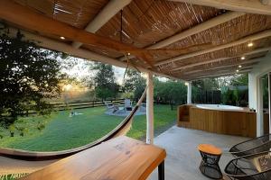 een veranda met een hangmat en een tuin bij Sitio Sunset Joy in Santa Maria