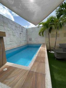 a swimming pool in a house with palm trees at Casa Familiar Diamante in Heroica Alvarado