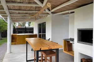 an outdoor patio with a wooden table and a fireplace at Sitio Sunset Joy in Santa Maria