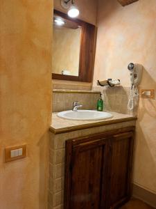 a bathroom with a sink and a mirror at Pienzalettings "Suites" in Pienza