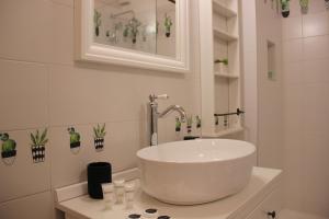 a white bathroom with a sink and a mirror at [Centro storico] deluxe flat in Udine