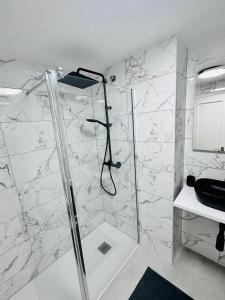 La salle de bains est pourvue d'une douche avec une porte en verre. dans l'établissement Playa Dona Sofia Bella, à Fuengirola