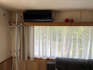 a window with a television on top of it at La caravane de Maminou in Stavelot