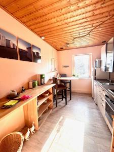 a kitchen with wooden ceilings and a table and chairs at Ferienwohnung TINA in Naumburg