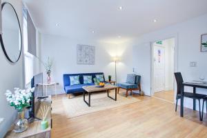 a living room with a blue couch and a table at Gorgeous 1 Bedroom Property in London