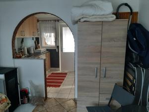 Erdei fenyö vendeghaz في لينتي: غرفة معيشة مع مرآة ومطبخ