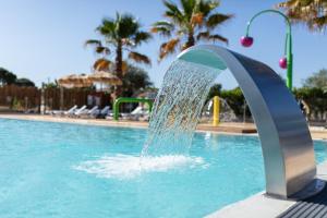 a water fountain in a swimming pool at Camping Les Amandiers in Castelnau-de-Guers