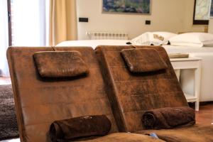 a brown couch sitting in front of a bed at Casita Garden&Spa in Carini +29 photos