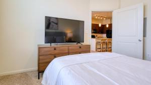 a bedroom with a flat screen tv on a dresser at Landing - Modern Apartment with Amazing Amenities (ID8209X45) in Houston