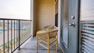 une chaise en osier assise sur le balcon d'une maison dans l'établissement Landing - Modern Apartment with Amazing Amenities (ID8209X45), à Houston