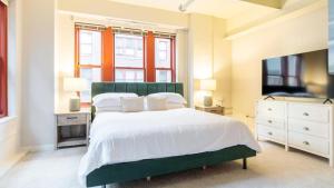 um quarto com uma cama grande e uma televisão em Landing - Modern Apartment with Amazing Amenities (ID1613X37) em Pittsburgh