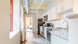 a kitchen with white cabinets and a stainless steel refrigerator at Landing - Modern Apartment with Amazing Amenities (ID1613X37) in Pittsburgh