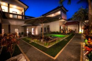 an external view of a house with an umbrella at Serendipity Bali in Sanur