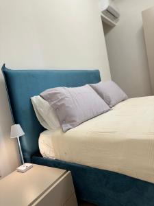 Una cama con cabecera azul en una habitación. en San Lorenzo Luxury, en Roma 6 fotos más