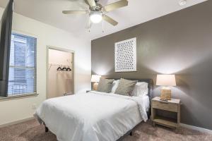 a bedroom with a white bed and a ceiling fan at Landing - Modern Apartment with Amazing Amenities (ID5045X8) in San Antonio