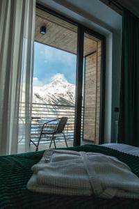a bedroom with a bed and a view of a mountain at Hotel Grand View in Stepantsminda