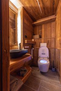 a wooden bathroom with a toilet and a sink at ValmalencoAlpina in Caspoggio