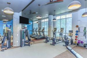un gimnasio con cintas de correr y equipo cardiovascular en un edificio en Downtown Houston Cozy Queen Suite en Houston