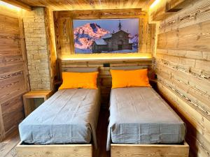 卡斯波喬的住宿－ValmalencoAlpina，小屋内的两张床,墙上挂着一幅画