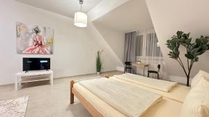 Moderne Appartement في نورنبرغ: غرفة نوم بيضاء مع سرير وتلفزيون