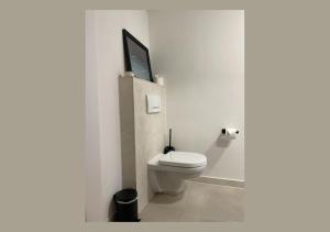 a bathroom with a toilet with a tv on the wall at Urban Retreat - Central and Historic in Würzburg +13 photos