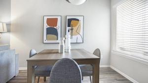 ein Esszimmer mit einem Tisch mit Stühlen und Gemälden in der Unterkunft Landing - Modern Apartment with Amazing Amenities (ID7412X03) in Orlando