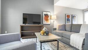 ein Wohnzimmer mit einem Sofa und einem TV in der Unterkunft Landing - Modern Apartment with Amazing Amenities (ID7412X03) in Orlando